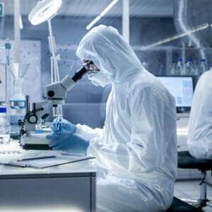 Scientists in the laboratory wearing protective clothing doing experiments