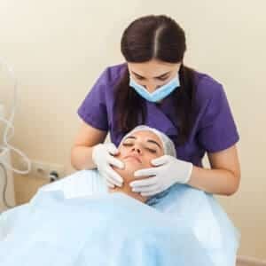A nurse is giving a beauty treatment to a client