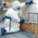 An equipment inspector in protective coverall during an inspection