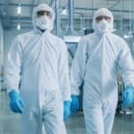 Two workers in protective coveralls