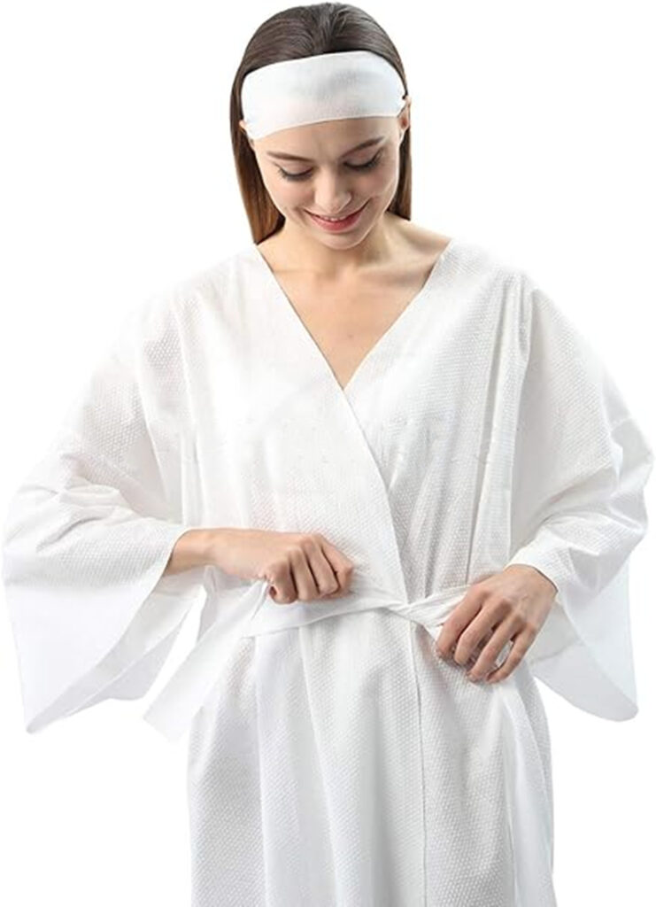 Woman in white spa robe tying waistband.