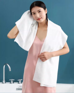 Femme avec une serviette dans une salle de bain.