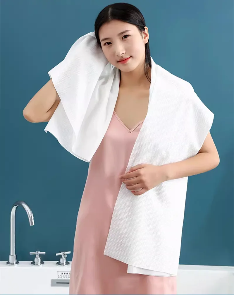 Woman with towel in bathroom setting.