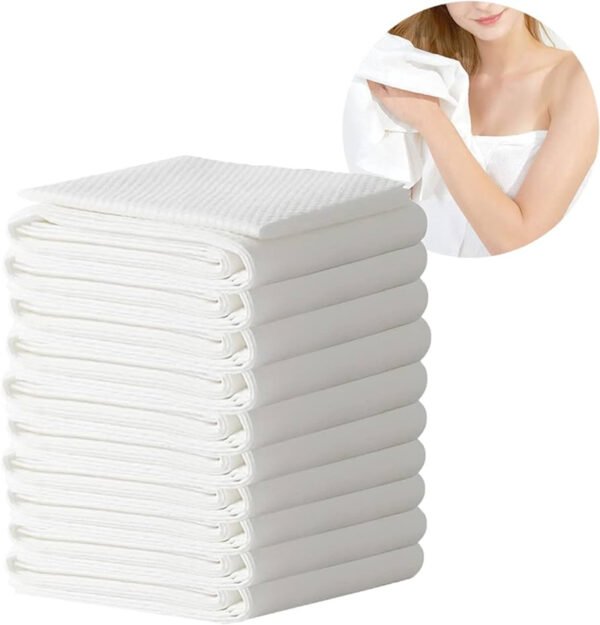 Stack of white towels with a woman holding one.