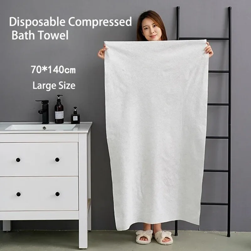 Woman displaying large disposable compressed bath towel.