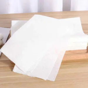Pila de hojas de cocina blancas que absorben el aceite sobre la mesa.