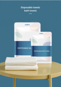 Packaged disposable bath towels on table.