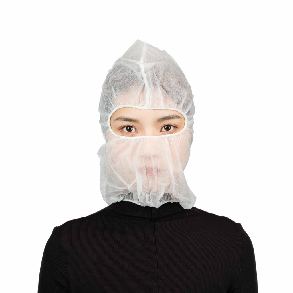Person wearing a white hair net and mask