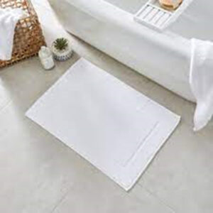 White bath mat next to bathtub
