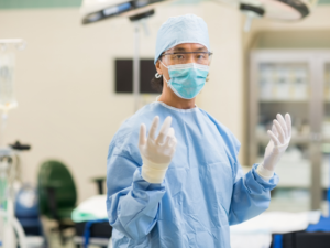 Surgeon in operating room wearing surgical attire.