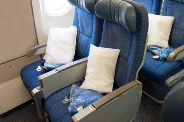 Airplane seats with pillows and blankets.