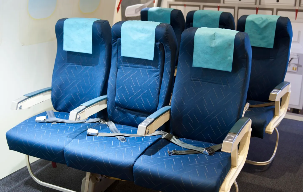 Empty airplane seats inside a cabin.