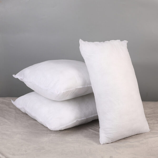 Three white pillows on a gray background.