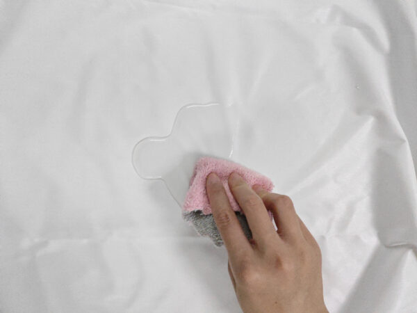 Cleaning spill with cloth on white surface.