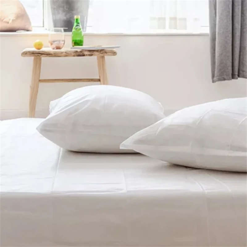 Clean white pillows on tidy bed