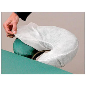 Person putting cover on massage table headrest