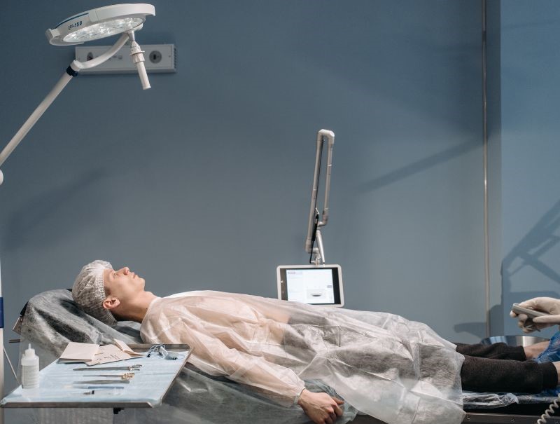 Personne dans une salle d'opération sous une lampe d'examen.
