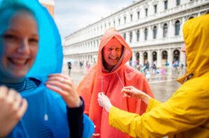 People laughing in colorful rain jackets outdoors.
