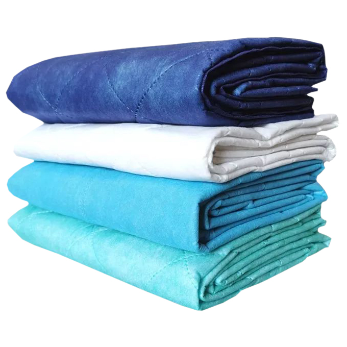 Stacked colorful quilted blankets in blues and white.