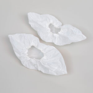 Cubrezapatos desechables blancos sobre fondo gris.