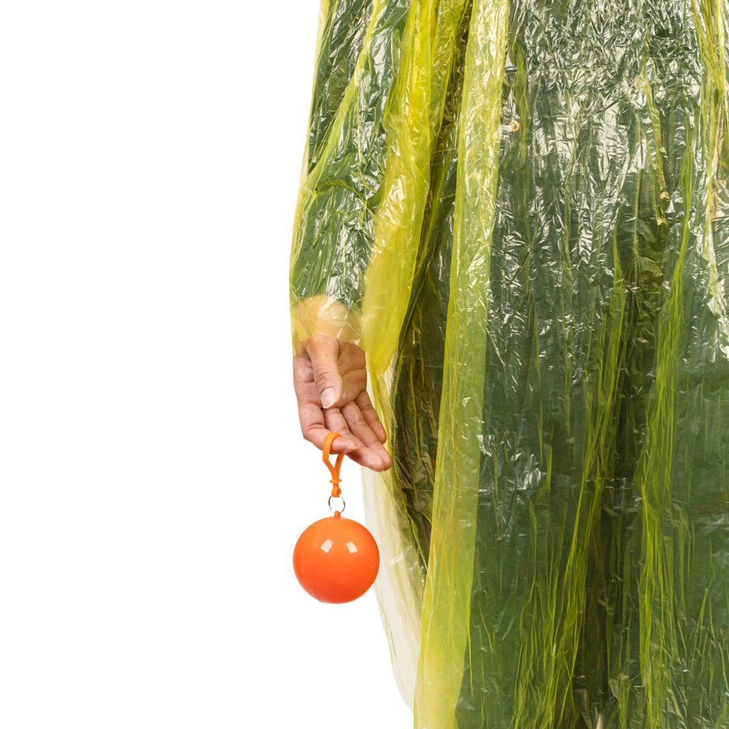 Persona sujetando una pelota naranja con chubasquero