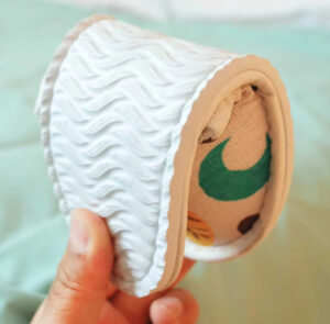 Sujeción de objeto cilíndrico texturizado con cubierta estampada.