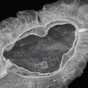 Transparent disposable shoe cover on black background.